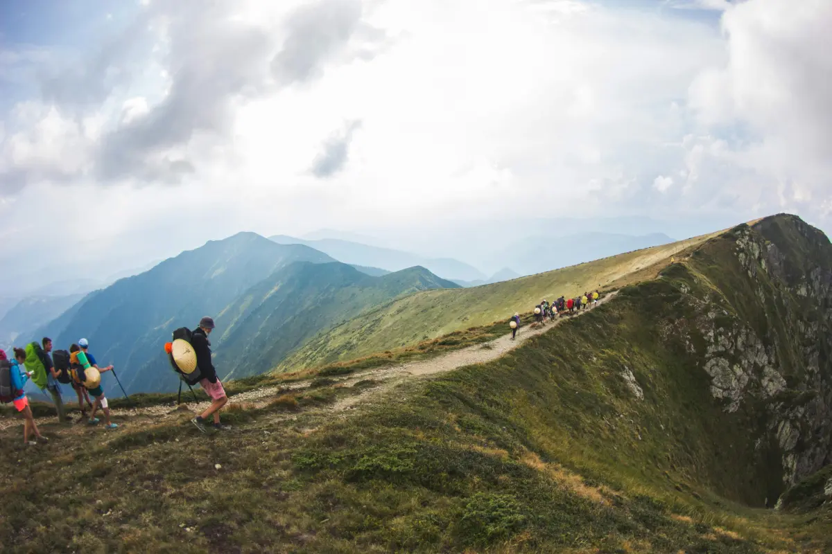 Group of hikers reaching a mountain summit in the UK.